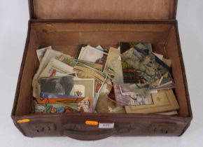 A vintage brown leather suitcase containing a collection of Victorian and later postcards to include