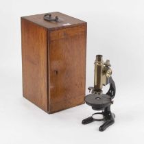 An early 20th century iron and lacquered brass monocular microscope, marked Cassel, in fitted oak