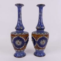 A pair of Royal Doulton stoneware vases, having a flared rim to slender neck and shouldered body,