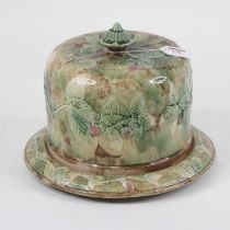 A Victorian majolica glazed cheese dome and cover, on a green ground relief decorated with