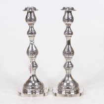 A pair of George V silver table candlesticks, the knopped stems with floral engraved decoration to a