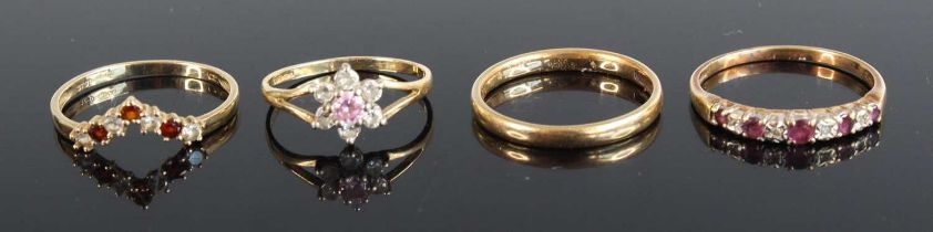 A 9ct gold wedding band, together with a 9ct gold amethyst set half eternity ring, a 9ct gold garnet
