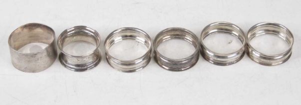 A set of four George V silver napkin rings; together with two other silver napkin rings, gross 2.5oz