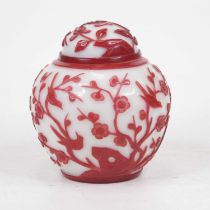 A Peking glass jar and cover, of baluster form, relief decorated with birds amidst flowering