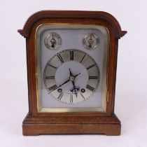 An early 20th century oak cased bracket clock, the silvered chapter ring showing Roman numerals
