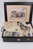 An early 20th century black painted metal deed box, containing a collection of postcards,