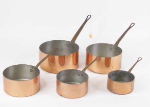A graduated set of five copper saucepans, each with brass handles, the largest dia.20cm