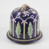 A Victorian majolica glazed cheese dome on stand, the cover on a blue ground with raised leaf