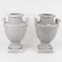 A pair of grey crackle glazed urns, each of baluster form with twin scroll handles, on square