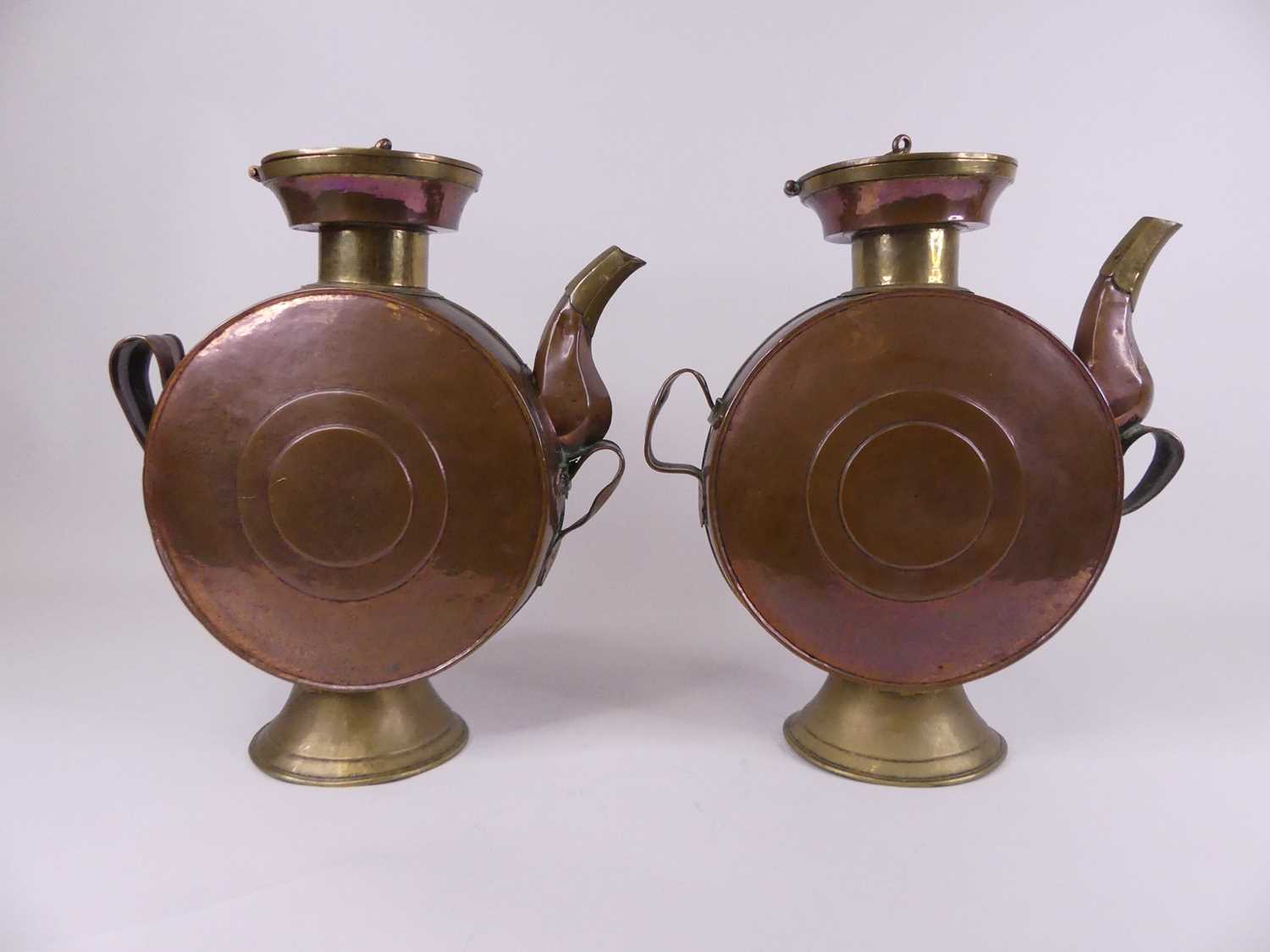 A pair of Eastern copper drum-shaped canisters, each having a hinged circular lid and hexagonal