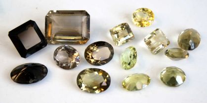 A collection of loose vari-cut lemon and smoky quartz stones, the smallest oval lemon quartz