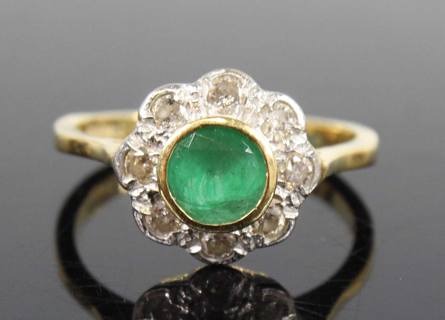 An 18ct yellow and white gold, emerald and diamond circular cluster ...