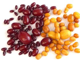 An assortment of loose butterscotch and cherry amber beads, comprising 43 butterscotch measuring