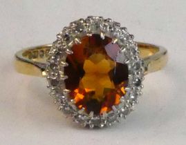 An 18ct yellow and white gold, citrine and diamond oval cluster ring, comprising a centre oval
