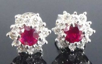 A pair of 18ct white gold, ruby and diamond circular cluster earrings, each with a centre round ruby