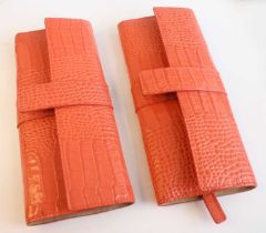 A pair of Smythson of Bond Street jewellery rolls, each in coral pink crocodile embossed leather, in
