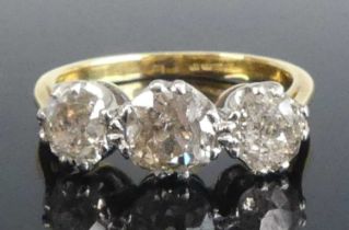 A yellow and white metal diamond three-stone ring, featuring three graduated old cut diamonds in