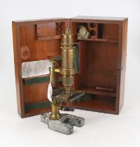 A 19th century lacquered brass and iron monocular microscope on a cast iron U-shaped base in