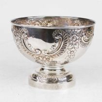 An Edwardian silver bowl, having repousse C-scrolling and floral decoration, on a domed foot,