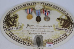 A WWII French Republique Francais 1939-1945 medal, and two others, mounted upon presentation