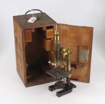 An early 20th century lacquered brass and iron monocular microscope having a rack and pinion