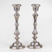 A pair of Elizabeth II silver table candlesticks, each having a single sconce with reeded edge, on