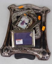 A silver clad easel photograph frame, repoussee decorated with swags and bows, London 1989, together