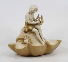 A Royal Dux porcelain figural dish in the form of a young boy playing a lyre seated on a clam shell,