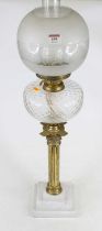 A 20th century oil lamp having clear glass chimney and etched frosted glass shade on brass burner,