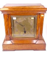 A late Victorian walnut cased mantel clock of architectural form, the copper dial with applied