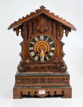 An early 20th century oak cased cuckoo clock having a Gothic style fret carved case, painted chapter
