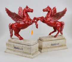 A pair of painted cast iron Mobil Oil advertising figures, each in the form of a winged horse on a