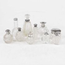 A collection of ten cut and moulded clear glass dressing table jars and scent bottles, each with