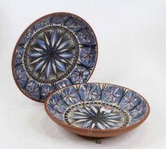 A pair of Jersey pottery dishes, each decorated with stylised flower to the centre and further