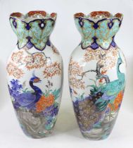 A pair of Japanese pottery vases of baluster form each having a flared reticulated neck, enamel