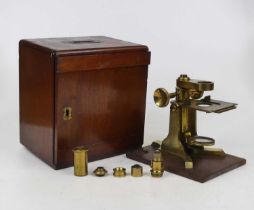 A 19th century monocular microscope base by Baker, the mechanical stage above adjustable mirror, a Y
