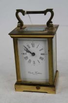 A Charles Frodsham lacquered brass carriage clock, the enamel dial showing Roman numerals, having