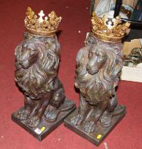 A pair of bronzed painted composite figures of lions, each modelled wearing a crown seated on a