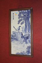 A Chinese blue & white glazed pottery plaque, decorated in relief with elderly gentleman and child