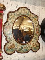 A walnut shaped oval wall mirror, the frame painted with medieval scenes, 70 x 59.5cm