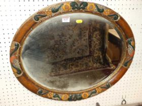 An early 20th century floral gilt and painted oval framed bevelled wall mirror, 49 x 59cm