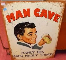 A printed tin wall sign titled Man Cave, 70 x 50cm