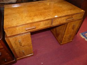 An Art Deco figured walnut twin pedestal writing desk, having twin frieze drawers, each pedestal