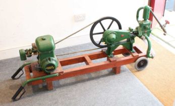 Wooden trolley mounted cast iron water pump, powered via belt-driven petrol engine, raised on wooden