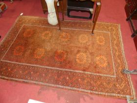 A Persian woollen rust ground bokhara rug, 208 x 145cm