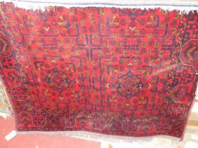 A Persian woollen red ground bokhara rug, 195 x 130cm
