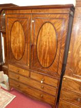 A Regency mahogany and ebony inlaid linen press, the twin upper doors enclosing interior linen