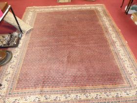 A Persian woollen red ground rug, with repeating central ground, within trailing tramline borders,