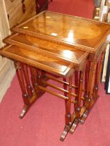 A contemporary yew wood and mahogany nest of three occasional tables, the largest width 54.5cm