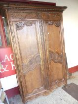 A large 19th century French provincial floral relief carved oak double door armoire, having
